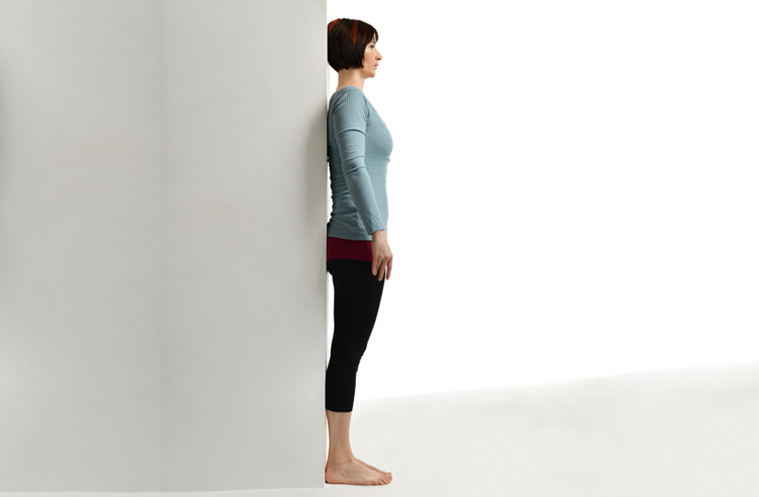 Posture wall test at home to check for head alignment and spinal curvature.