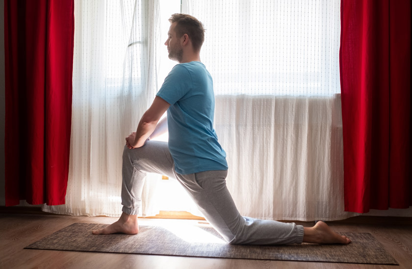 A man performing Hip Flexor Stretch to Treat Sciatica Pain at Home Naturally