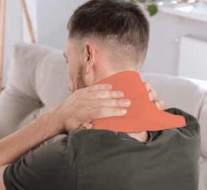 A man applies a heat wrap to relieve tension and pain in his neck.