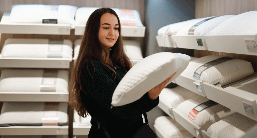 Woman debating purchasing a pillow in a store