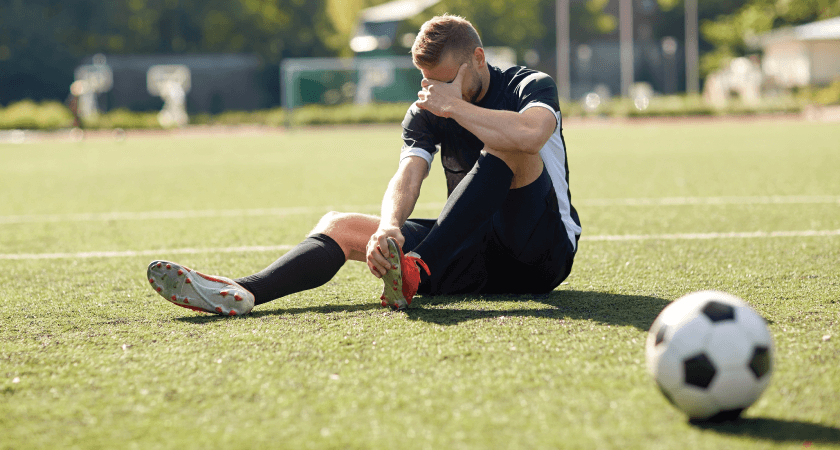 Male soccer player injured foot on the soccer field