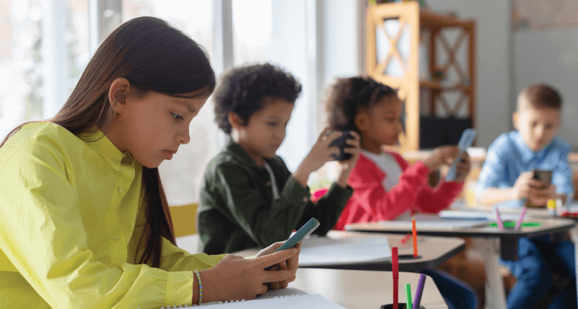 Middle school students using smartphones in a classroom setting