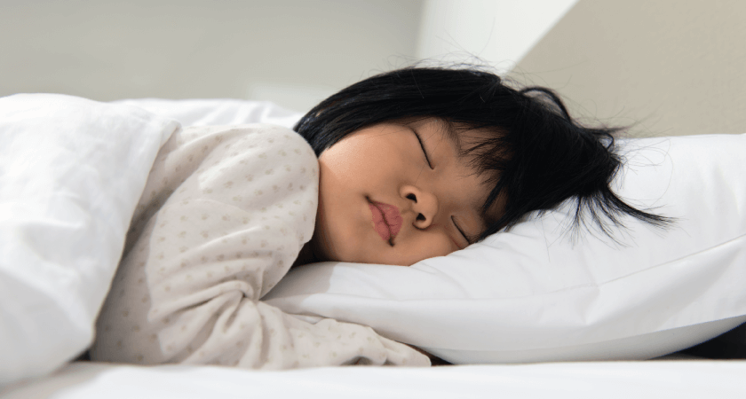 Child sleeping soundly on a bed with head and spine aligned