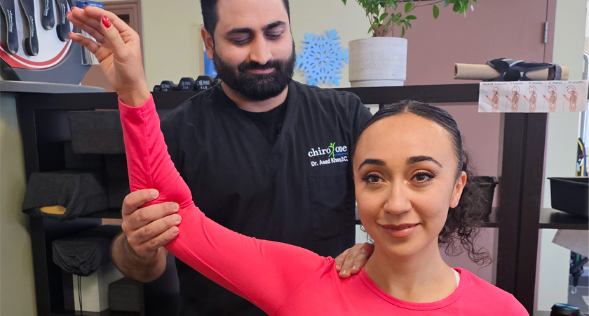 Woman doing arm exercises in clinic with guidance from a chiropractor