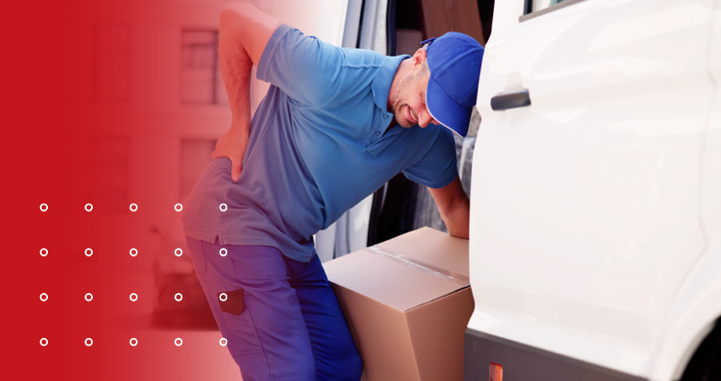 Man loading a box into a van and clutching back