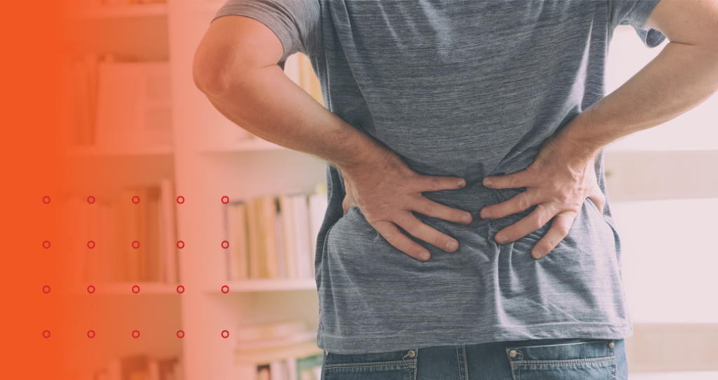 Man standing and clutching lower back