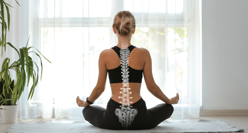 A woman sitting in a meditative yoga pose with an overlay of a healthy human spine and pelvis, illustrating the importance of spinal alignment for New Year wellness goals.